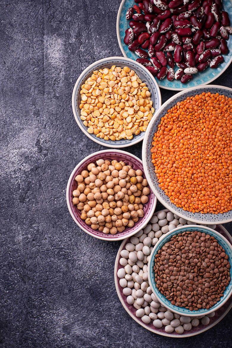 Various legumes. Chickpeas, red lentils, black lentils, yellow peas and beans. Selective focus. Top view