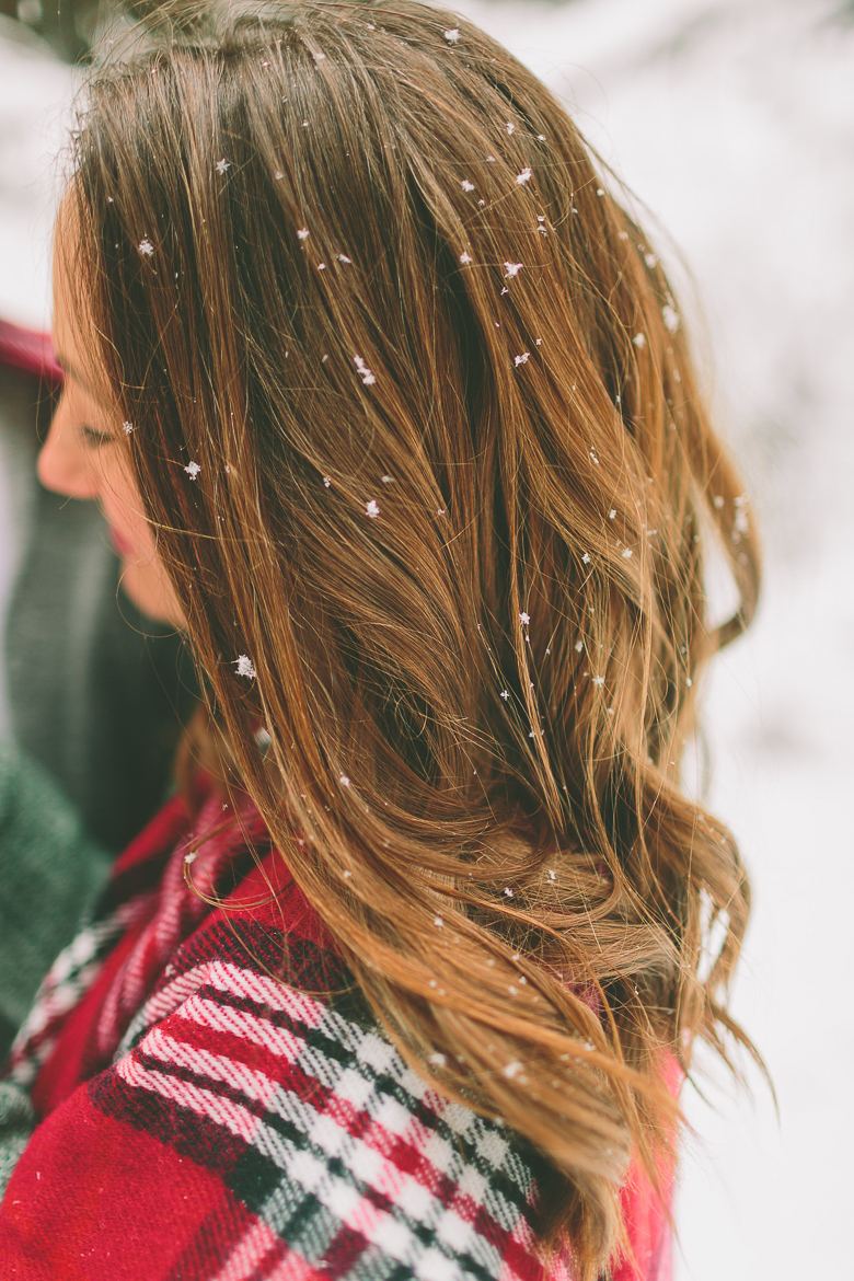 side view of a lady with long beautiful hair standing outside in the snow