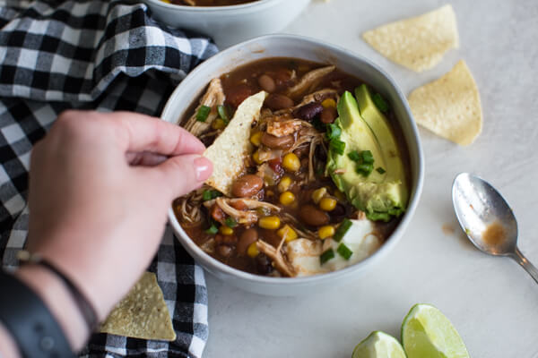Easy chicken enchilada soup recipe is great for meal prep and freezes well. Can be made in the slow cooker too! Healhty fall comfort food chili recipe FTW!