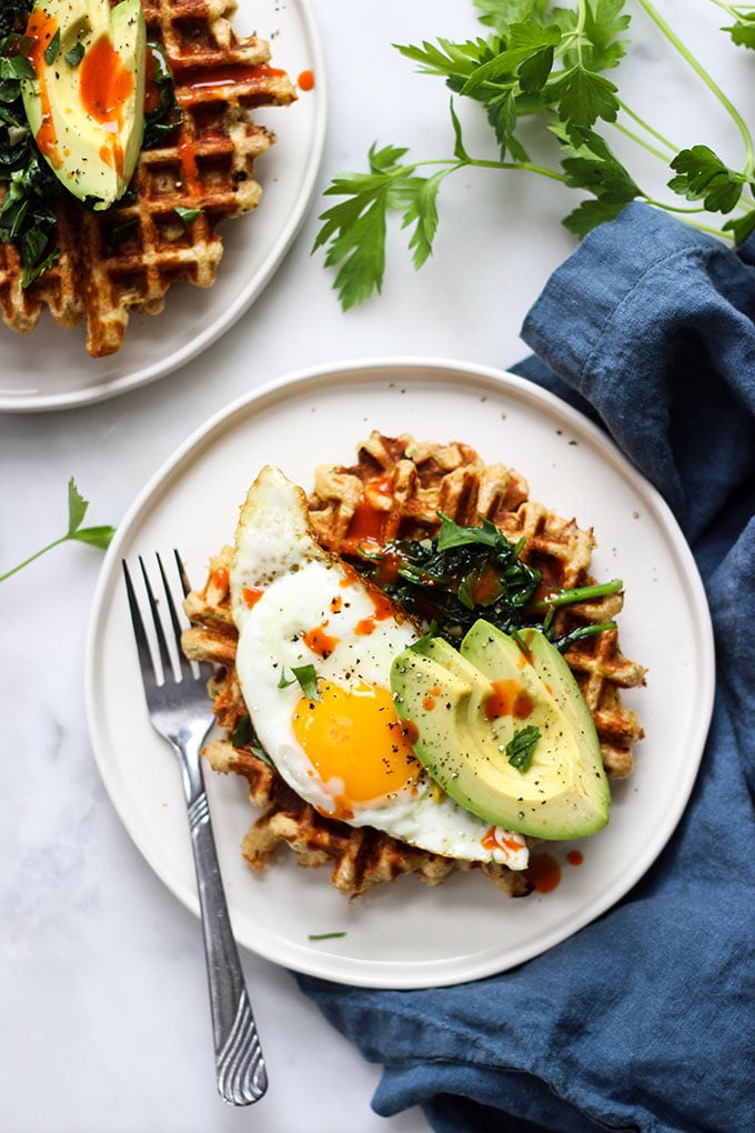 Cheddar Zucchini Waffles topped with a fried egg and spinach.