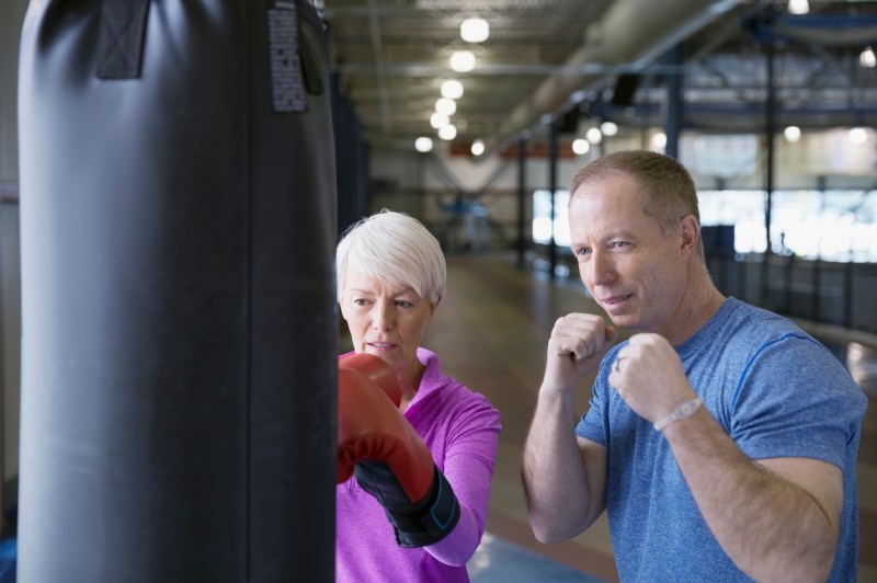 Woman boxing with personal trainer at gym