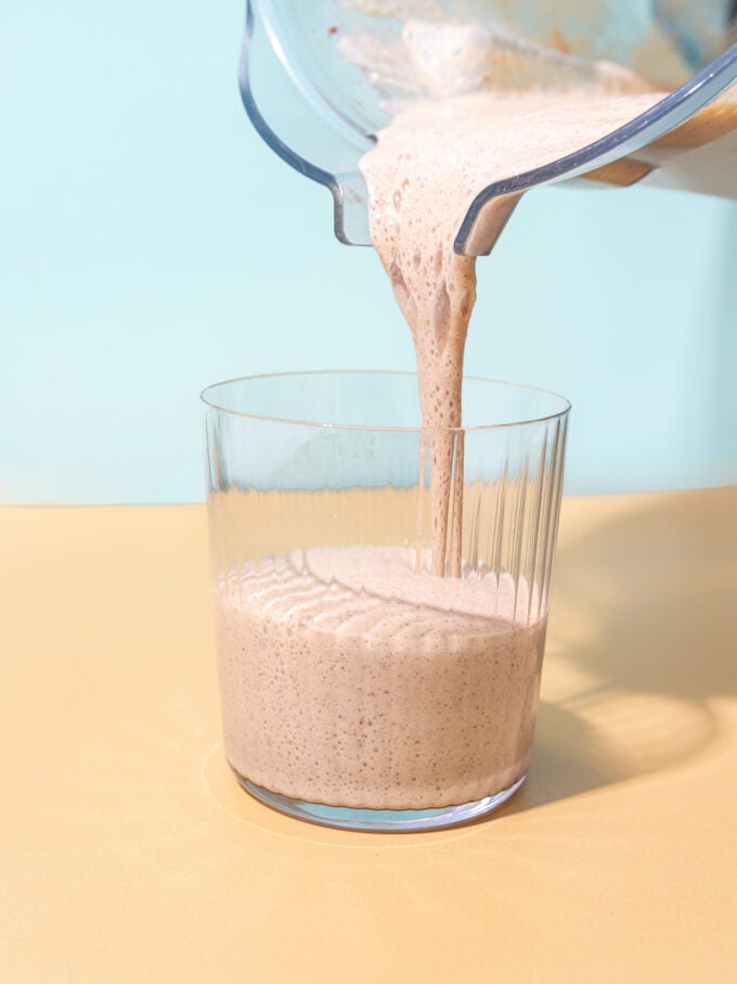 pouring smoothie into glass
