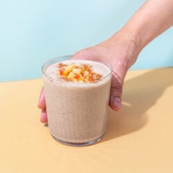 hand holding apple smoothie in glass