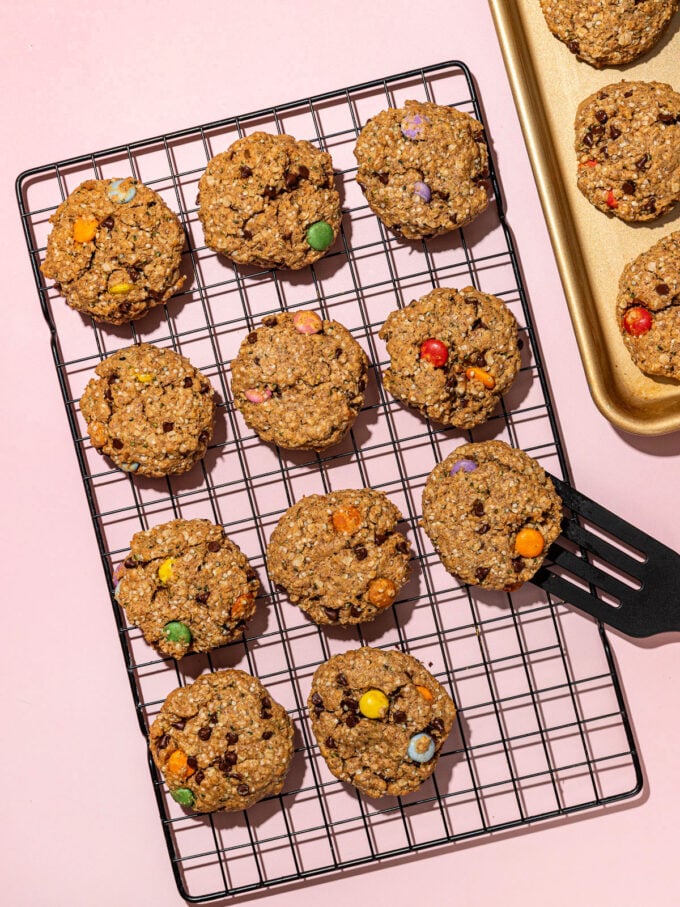 placing vegan monster cookies on wire rack with spatula