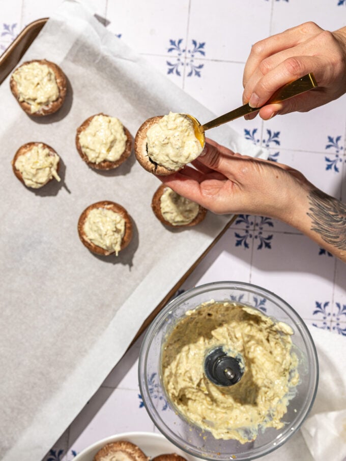 hand stuffing mushrooms with creamy dip